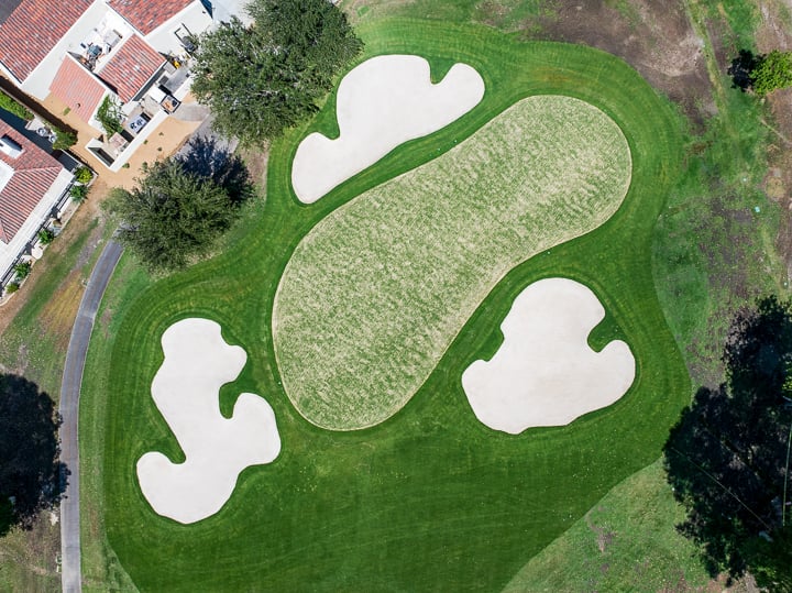 Overhead view of the green on Hole 18, showcasing its layout and final approach area at The Springs Country Club.
