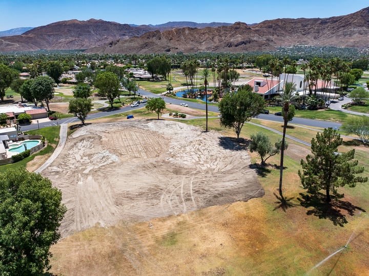 Hole 9 at The Springs Country Club post-demolition, fully cleared and prepped for shaping with exposed soil and defined work zones visible.