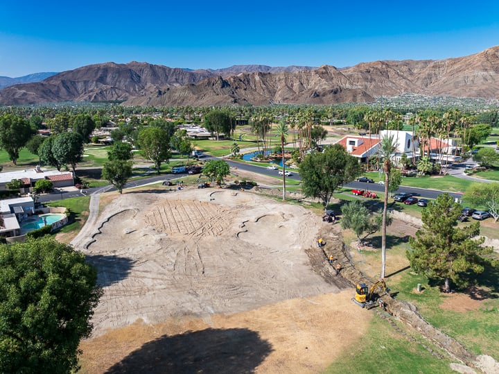 Hole 9 at The Springs Country Club post-demolition, fully cleared and prepped for shaping with exposed soil and defined work zones visible.