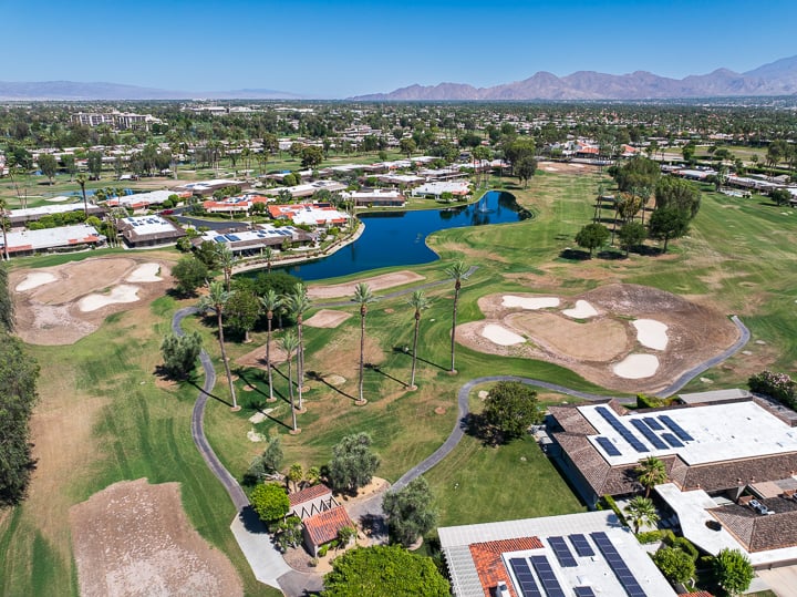 Aerial view of The Springs Country Club showing Hole 5 on the far left and Hole 4 on the short right, with fairways, greens, and desert terrain in frame.